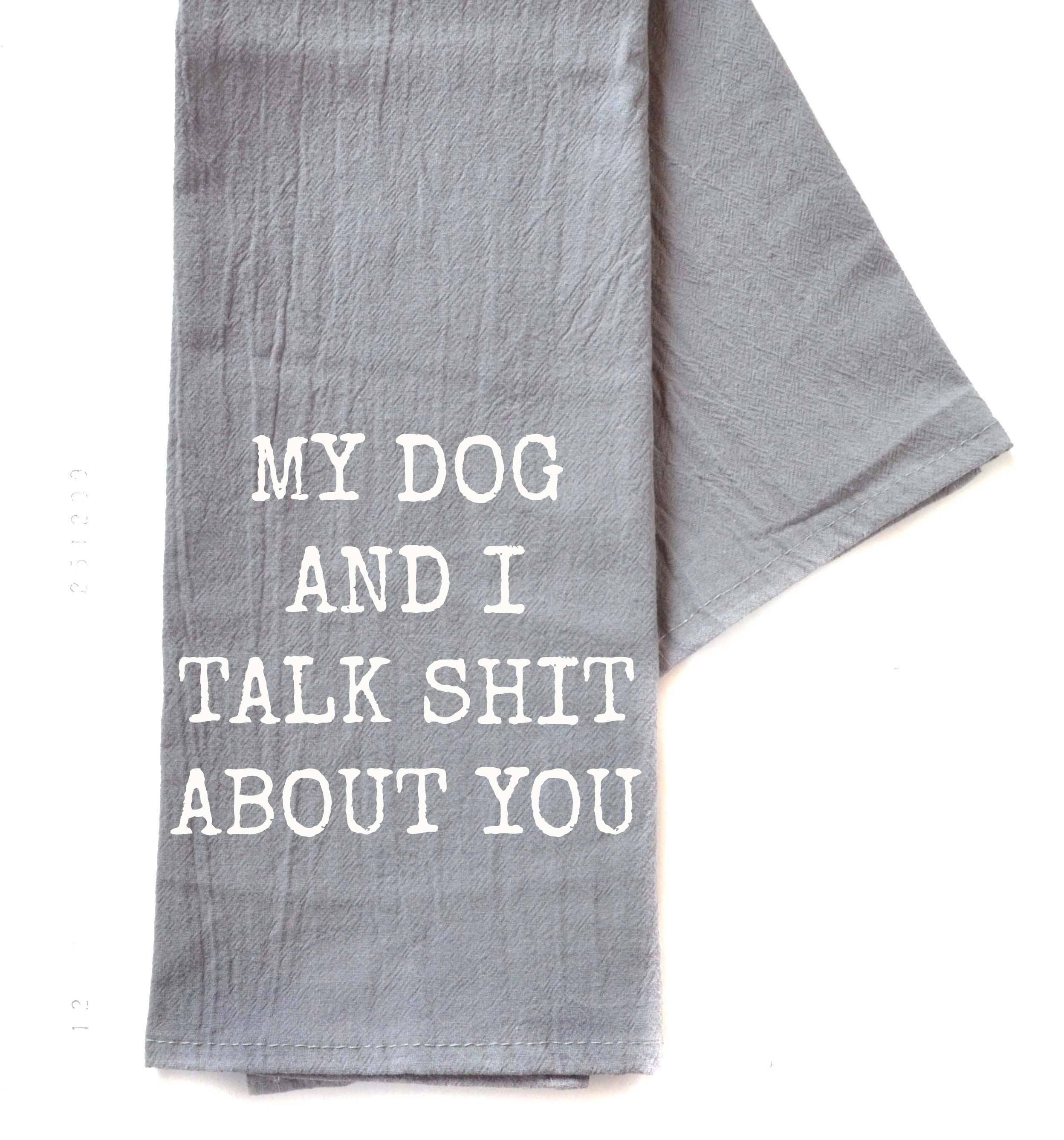 Gray dish towel with humorous black text saying, "My dog and I talk shit about you" The tone is playful and sarcastic.