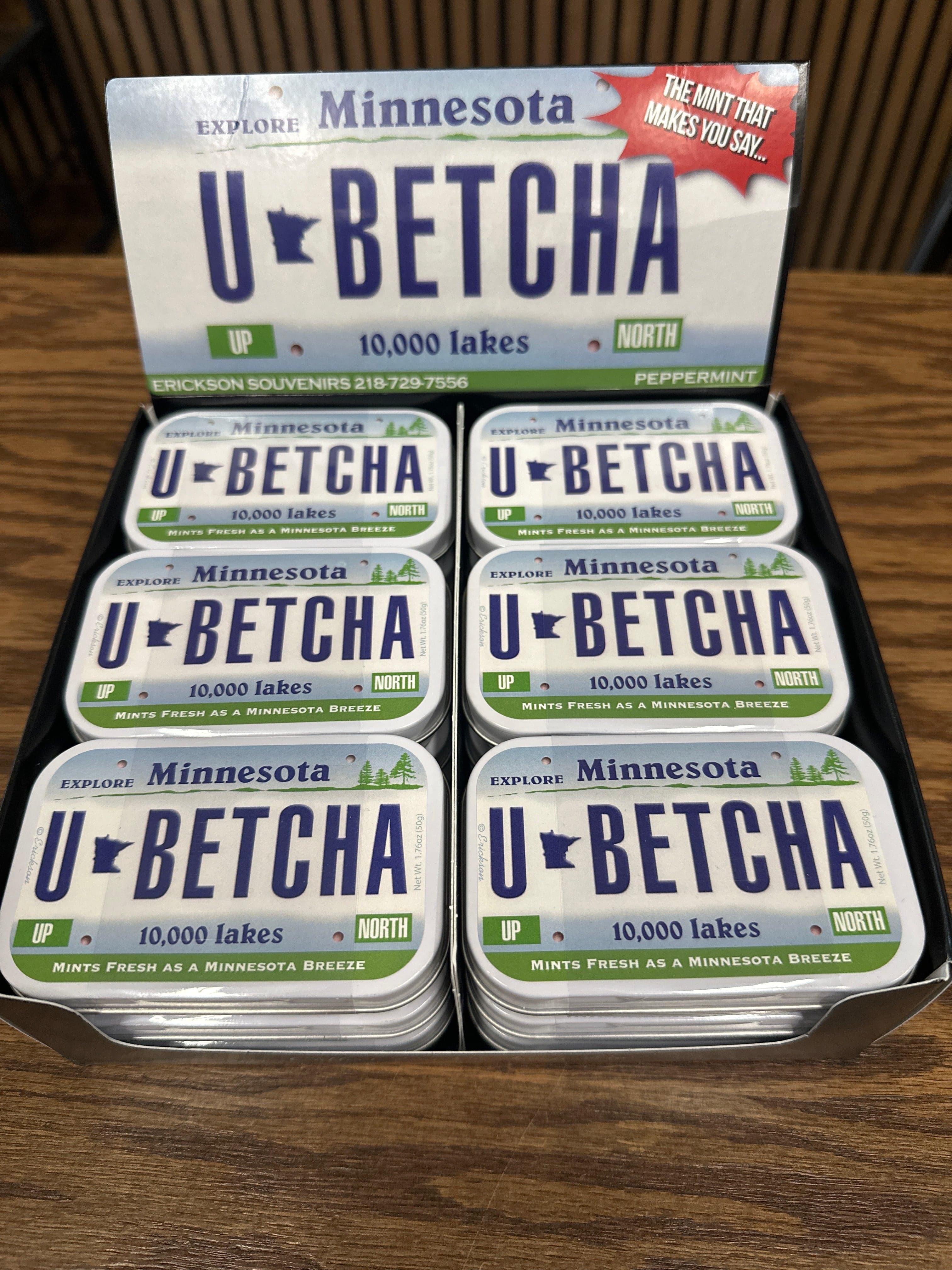 Display of 'U-Betcha' mints with Minnesota-themed packaging on a wooden surface.