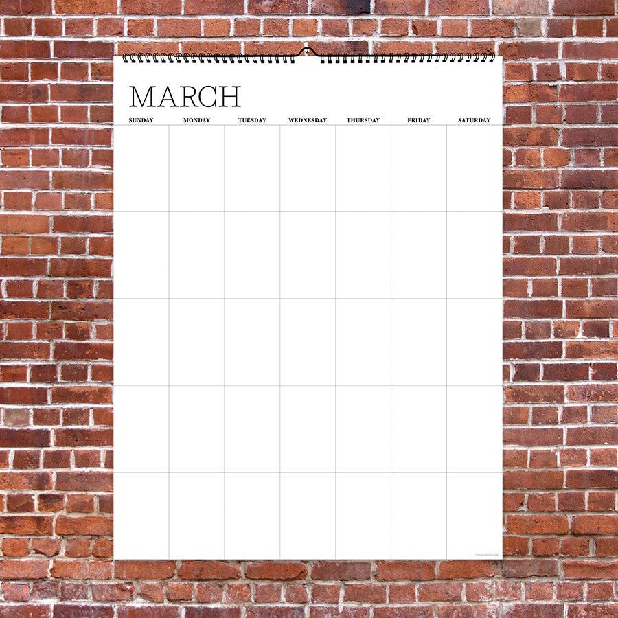 A blank March calendar is displayed on a red brick wall. The calendar is empty with grid lines for each day of the week, conveying a sense of anticipation.