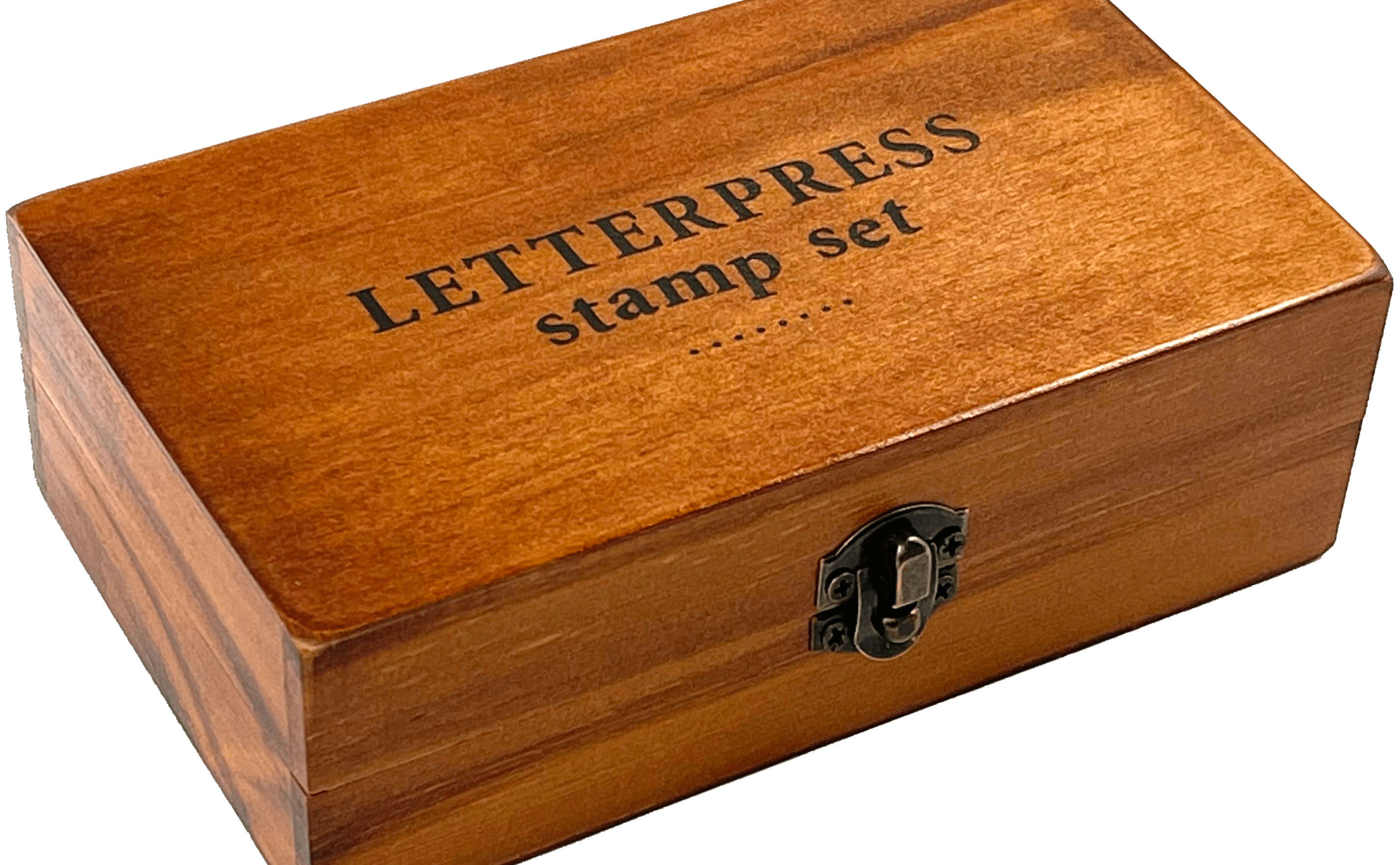 A wooden box labeled "LETTERPRESS stamp set" with a metal latch, resting on a transparent background. The box has a warm, polished finish.
