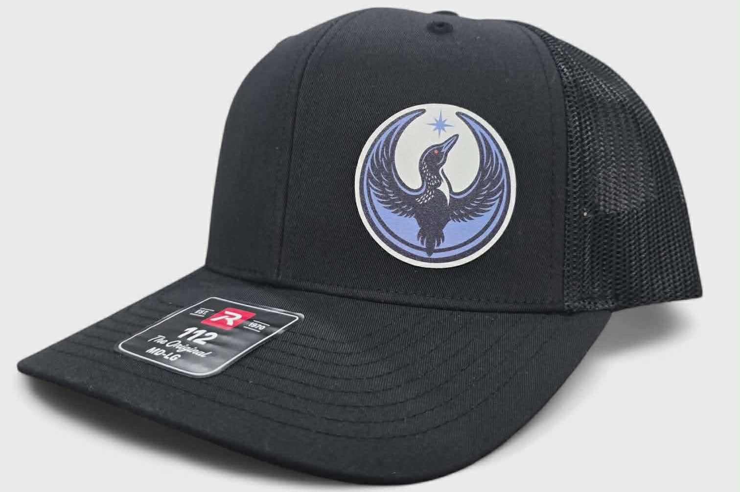 Black cap with a rebel loon logo on a light gray background