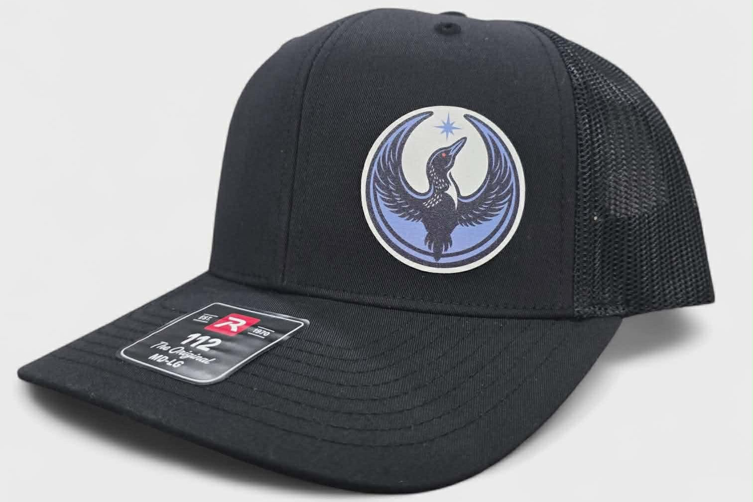 Black cap with a rebel loon logo on a light gray background