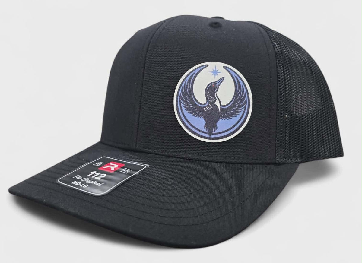 Black cap with a rebel loon logo on a light gray background
