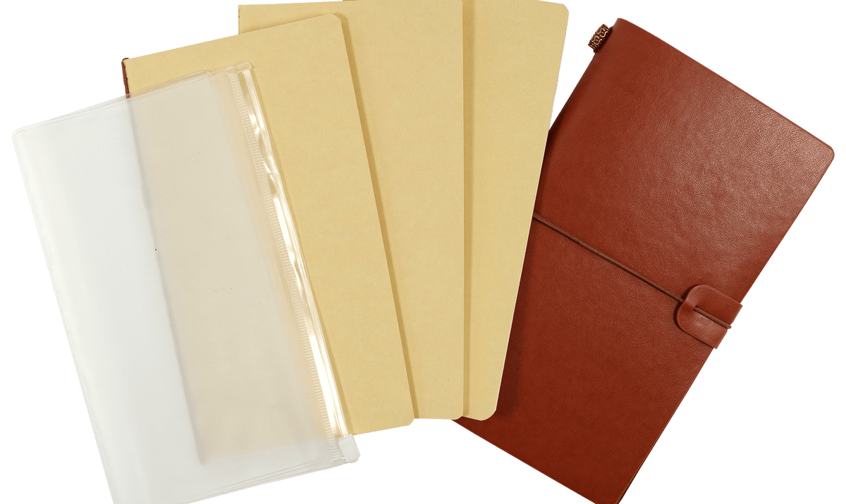 A selection of notebook dividers is displayed. From left to right: a white plastic pouch, two beige dividers, and a closed brown leather cover.