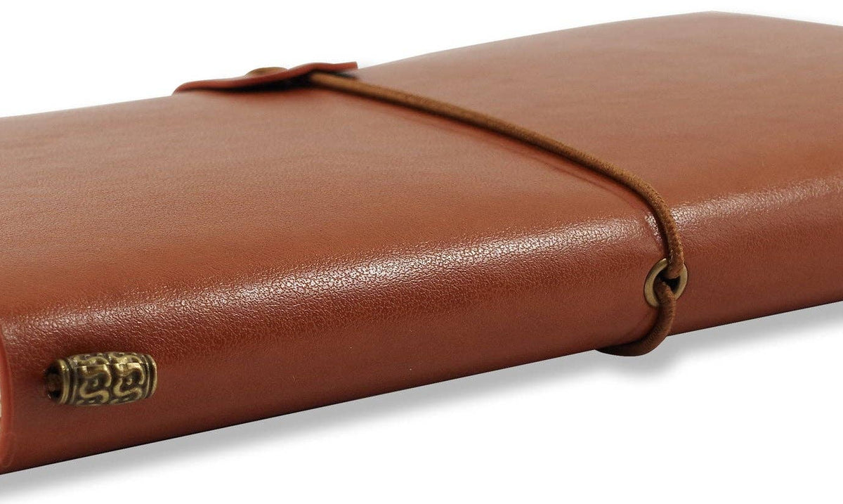 Brown leather notebook with a wraparound cord, closed, resting on a white surface. Pages slightly visible, conveying a vintage, elegant feel.