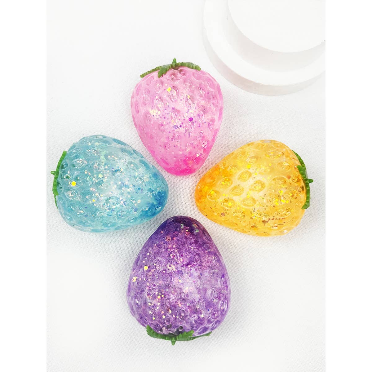 four colorful glittery squishy strawberries