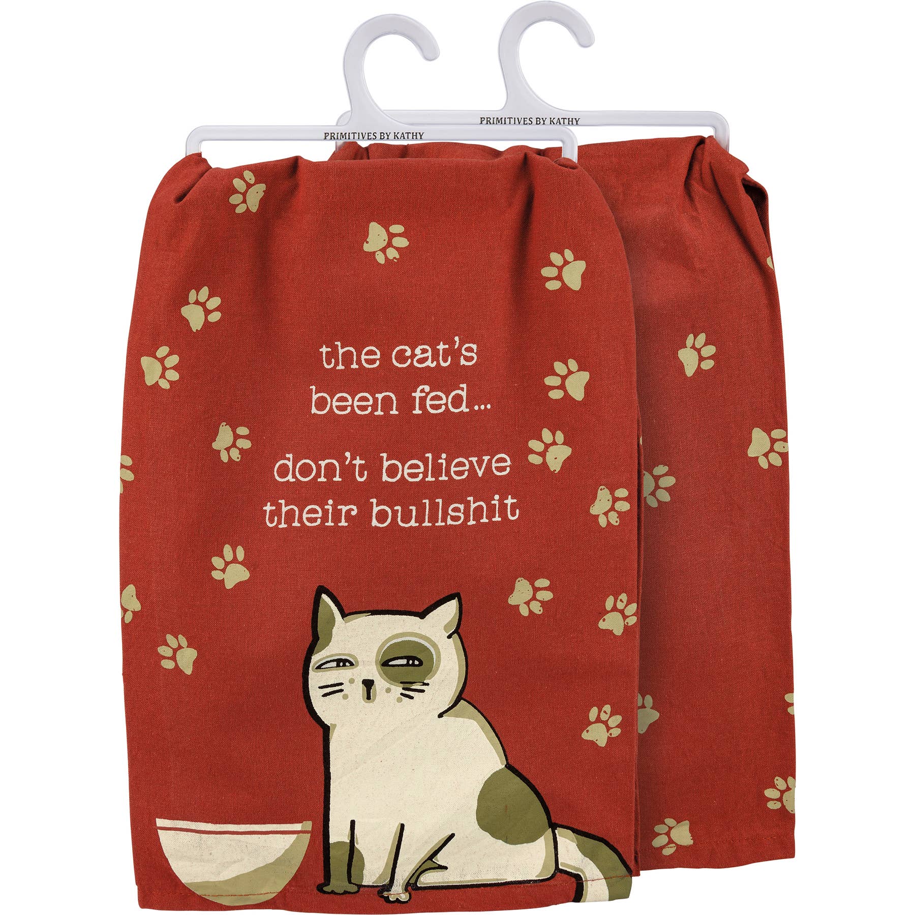 A whimsical kitchen towel with a red background, featuring cat paw prints. A cartoon cat sits below the humorous text: "the cat's been fed... don't believe their bullshit."