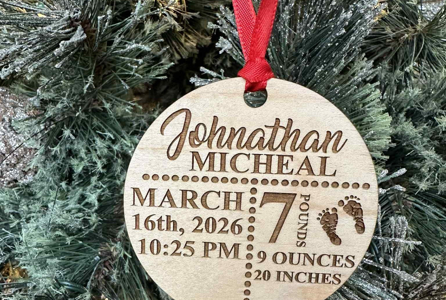 Wooden ornament with engraved baby details on a Christmas tree.