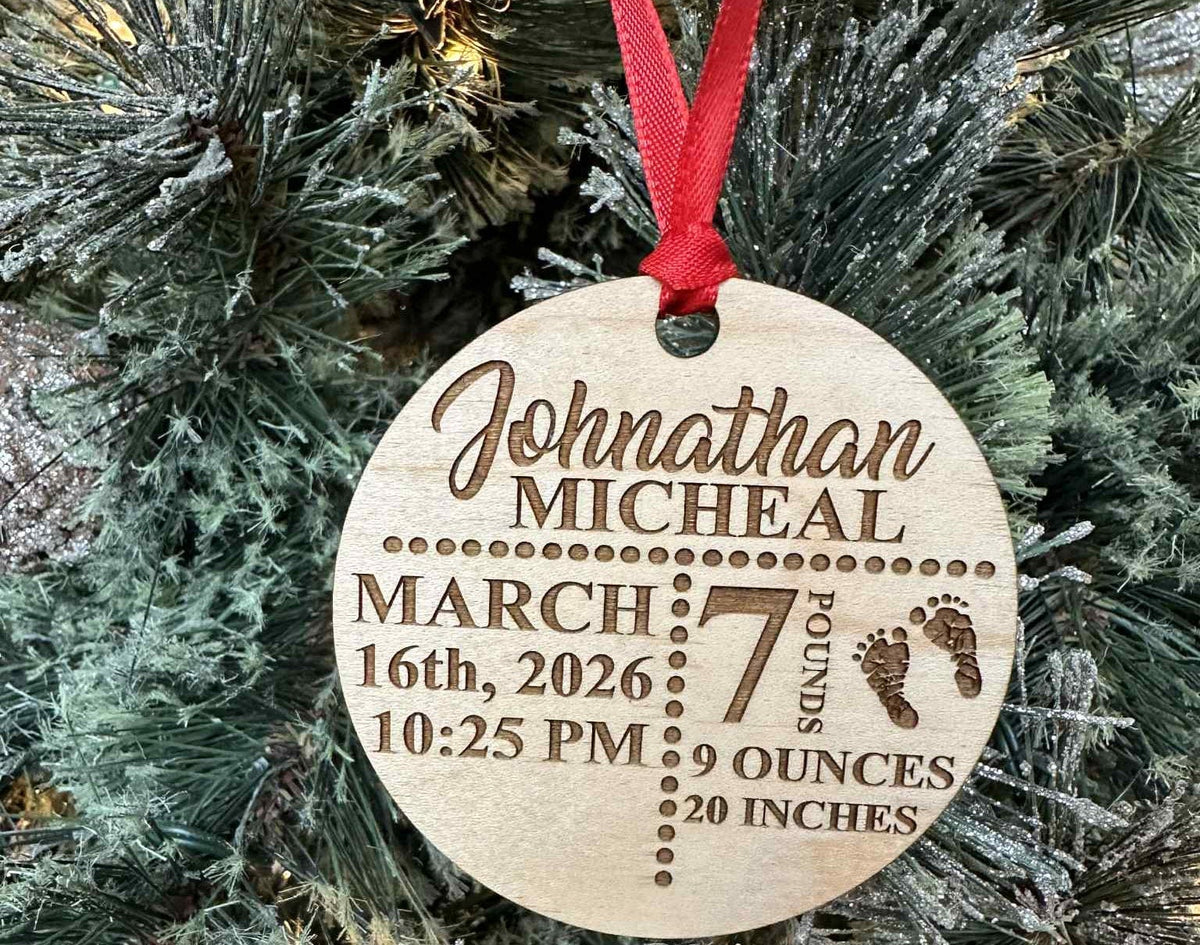 Wooden ornament with engraved baby details on a Christmas tree.