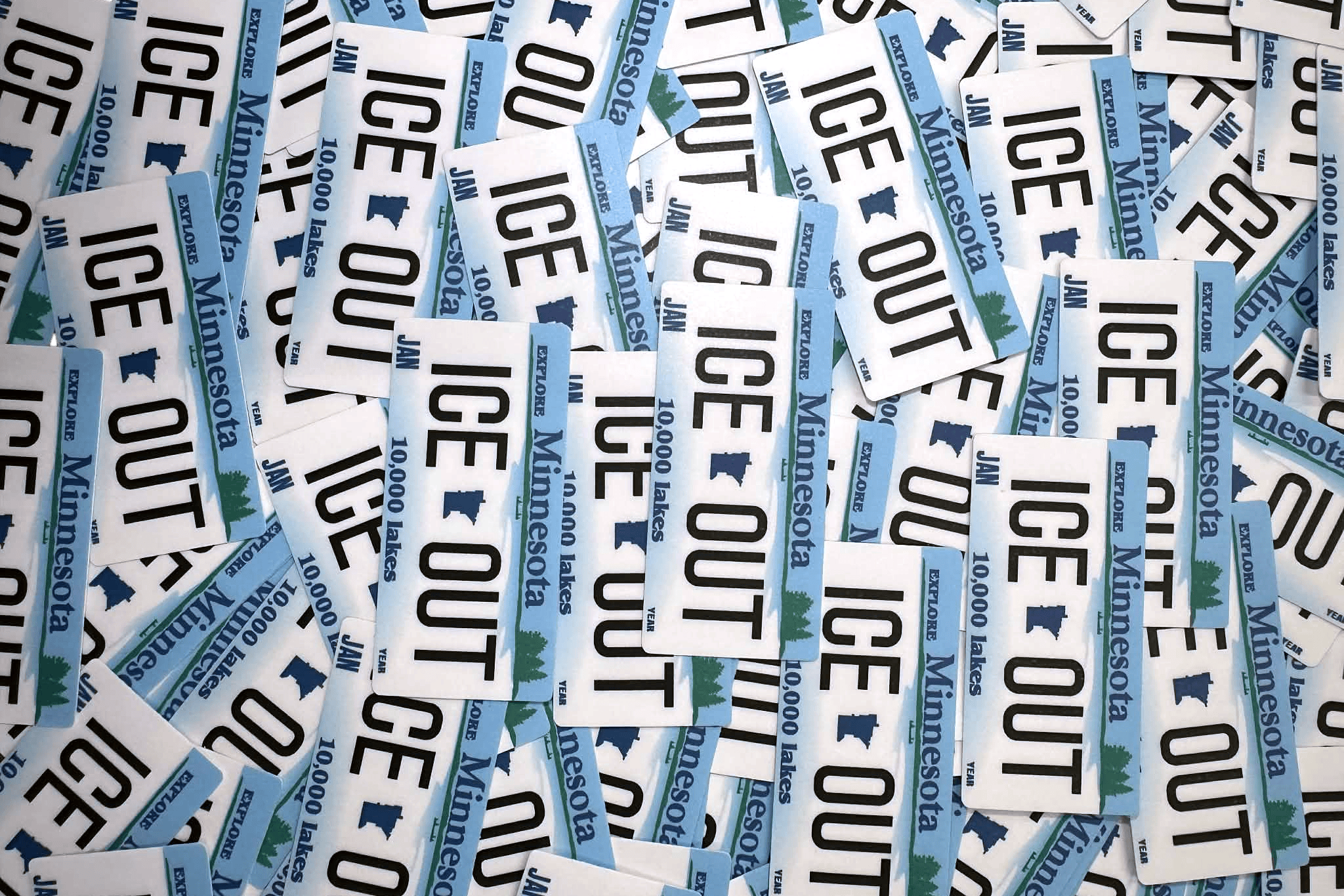 Collection of 'ICE OUT'Minnesota stickers scattered on a white background