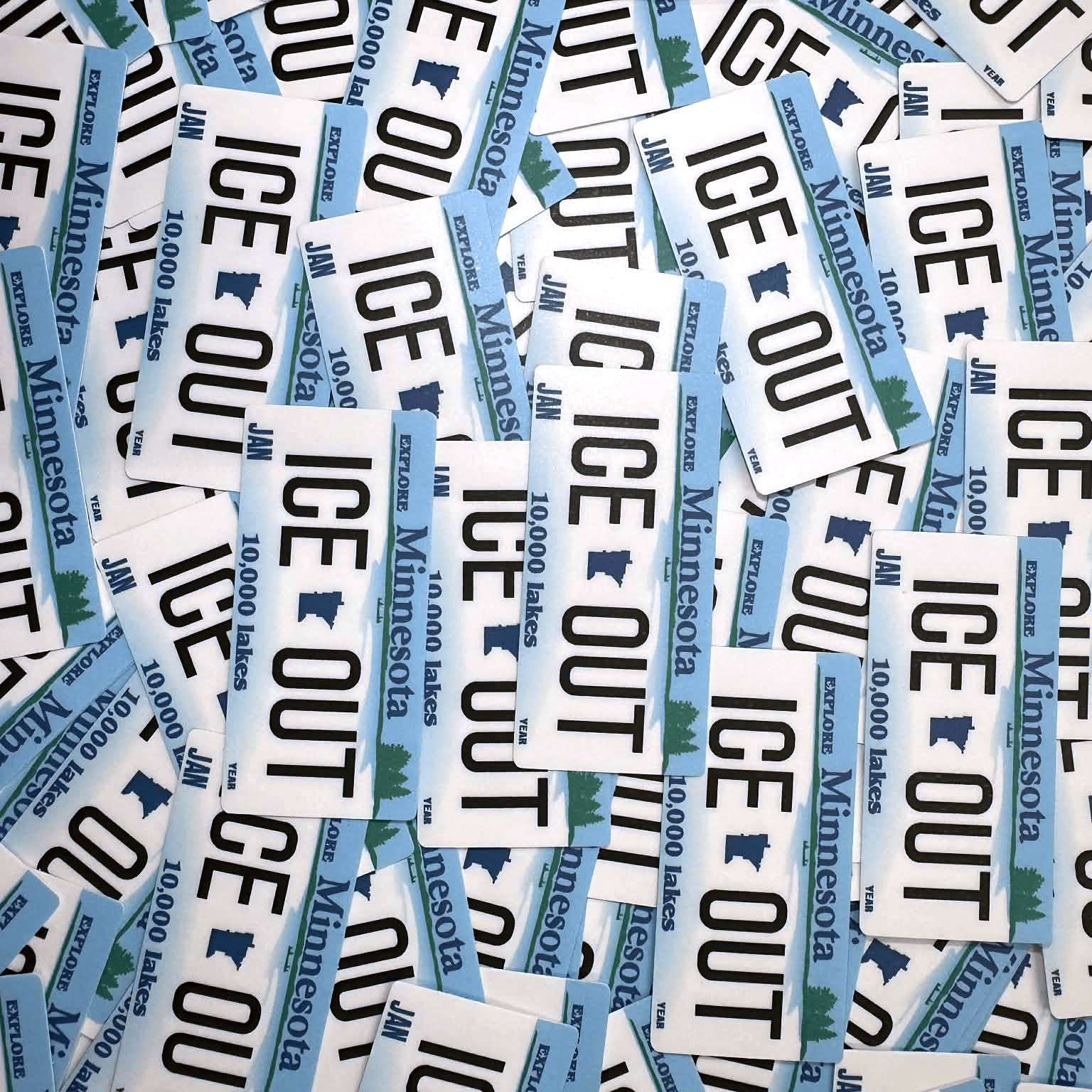 Collection of 'ICE OUT'Minnesota stickers scattered on a white background