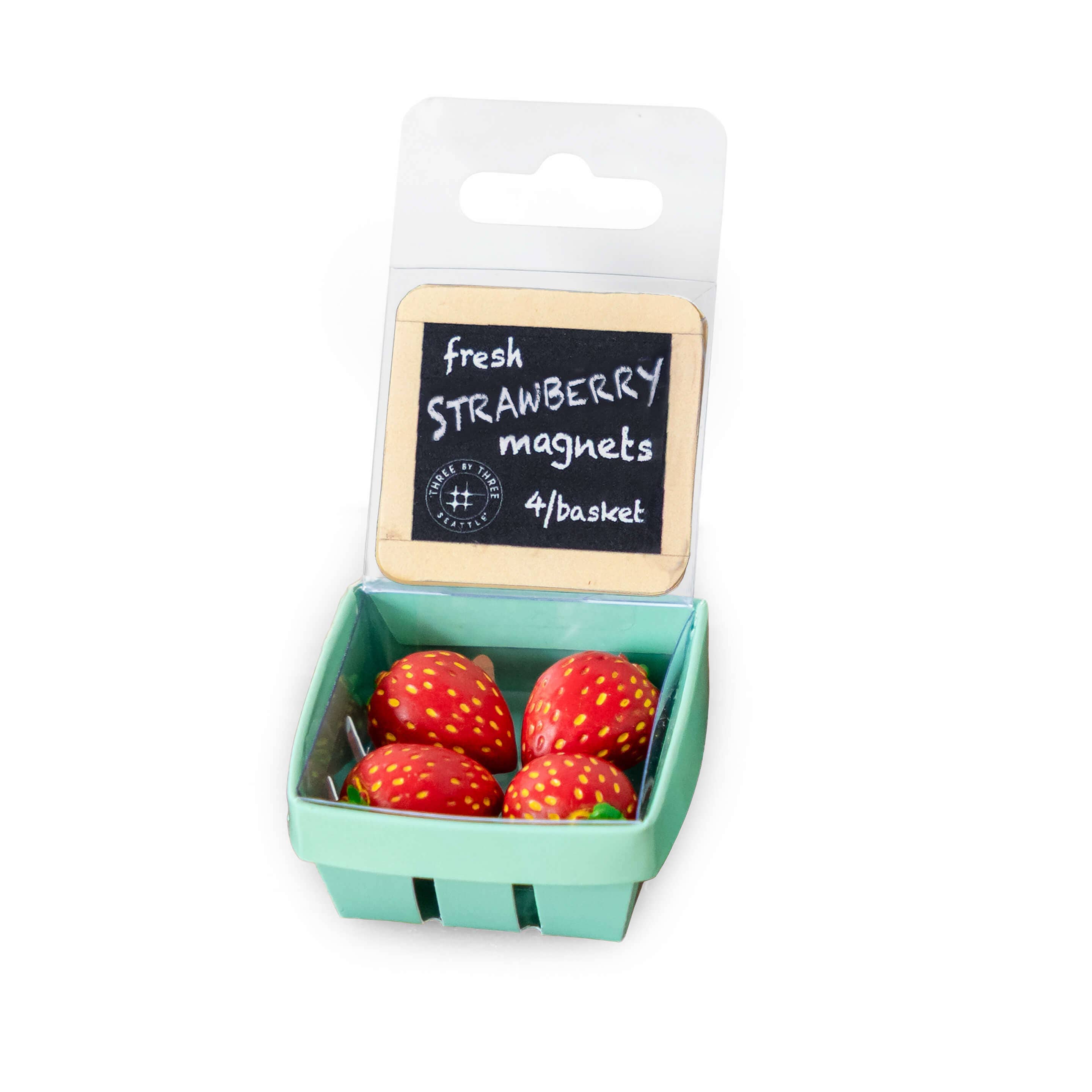 Packaged strawberry magnets with a small basket on a white background