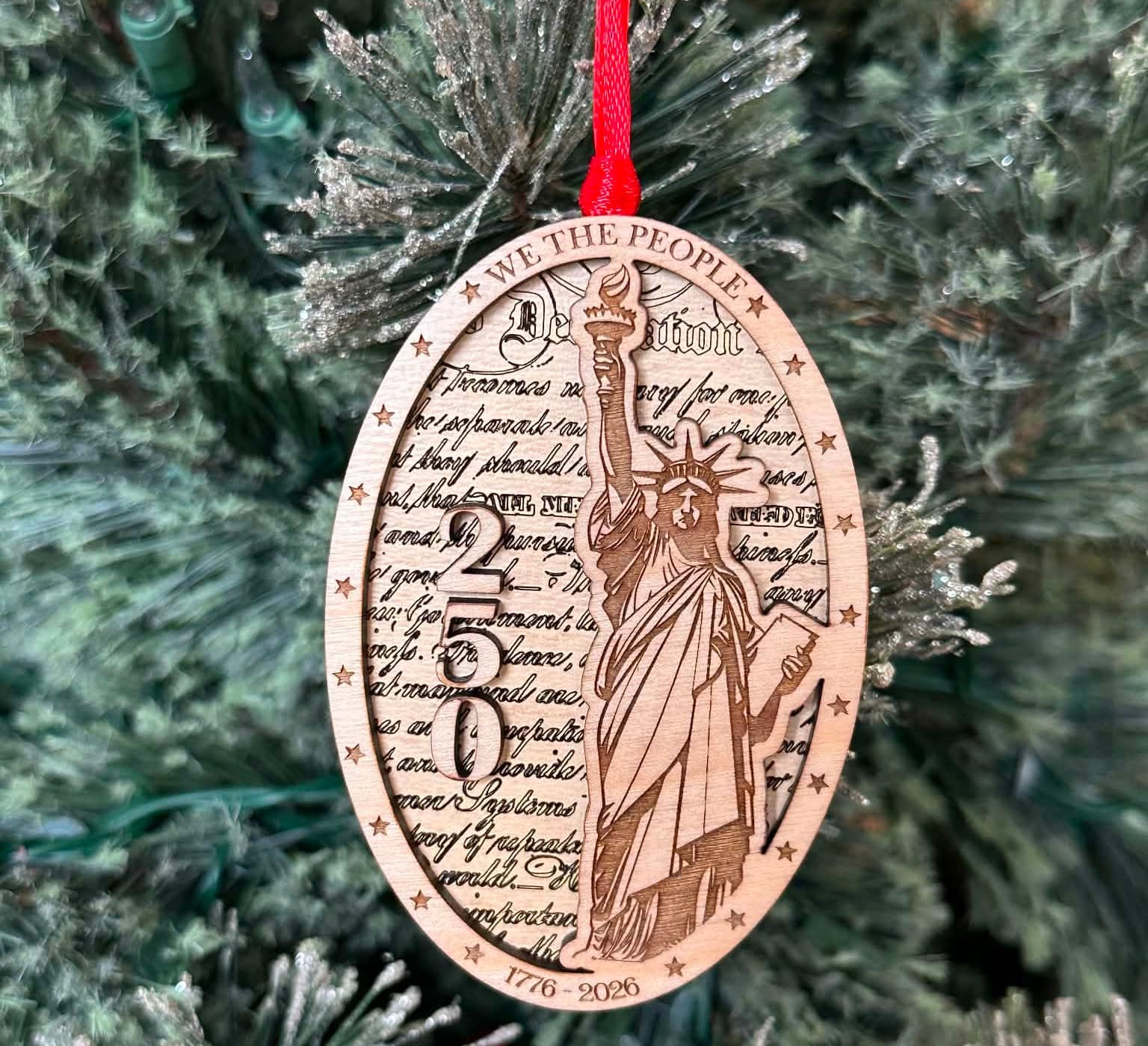 Statue of Liberty and the number 250 layered on top of another wood layer. We the people. 1776-2026