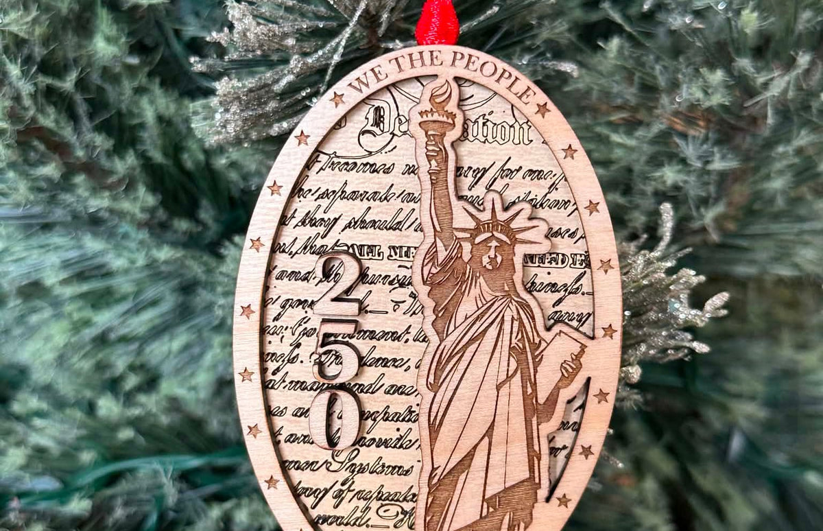 Statue of Liberty and the number 250 layered on top of another wood layer. We the people. 1776-2026