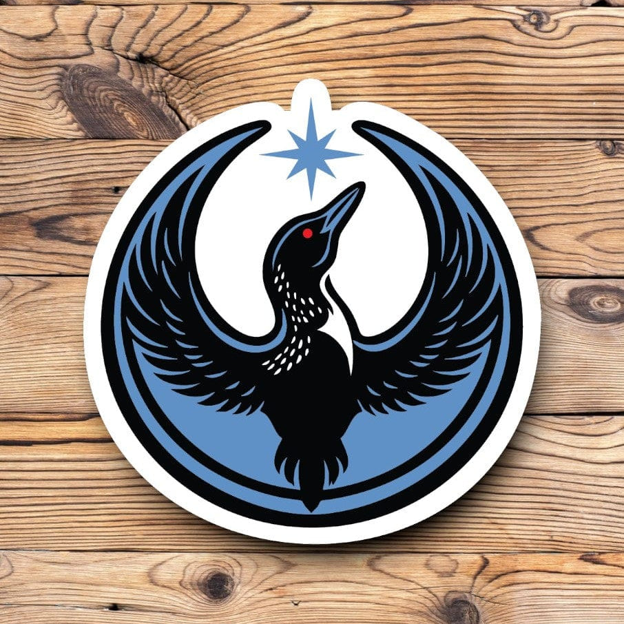 Image of Rebel Loon Sticker. Rebel Loon image shows a Loon Bird with wins raised up toward the north star. The bird is blue and black with a red eye and the north star is the same color blue. Sticker is a circular shape.