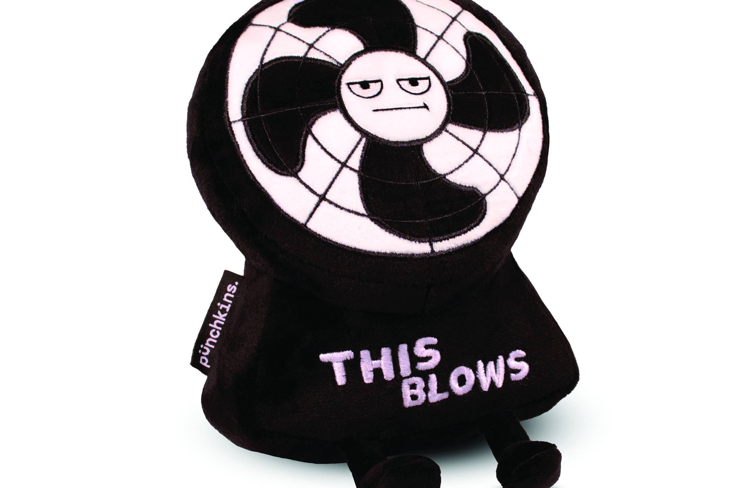 A plush toy designed to look like an annoyed electric fan with a black and white color scheme. The face of the fan has a grumpy expression, and the toy's base features the phrase 'THIS BLOWS' embroidered in bold, light-colored letters. It has small black legs and a tag on the side that reads 'punchkins.' The plush has a humorous and sarcastic design, making it a fun novelty item.