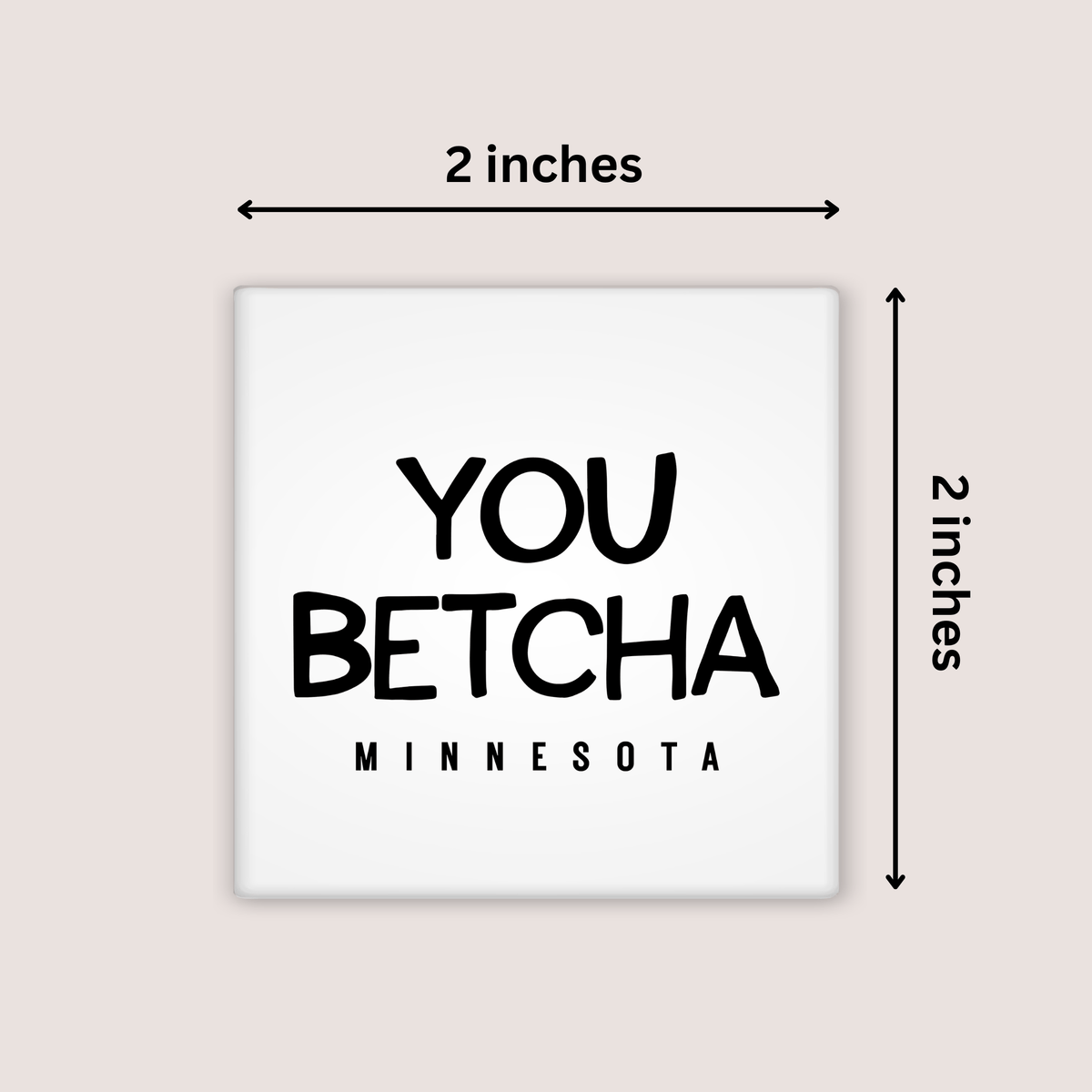A square white magnet with the phrase “YOU BETCHA MINNESOTA” in black text, shown on a light beige background with dimension arrows labeling it 2 inches by 2 inches.