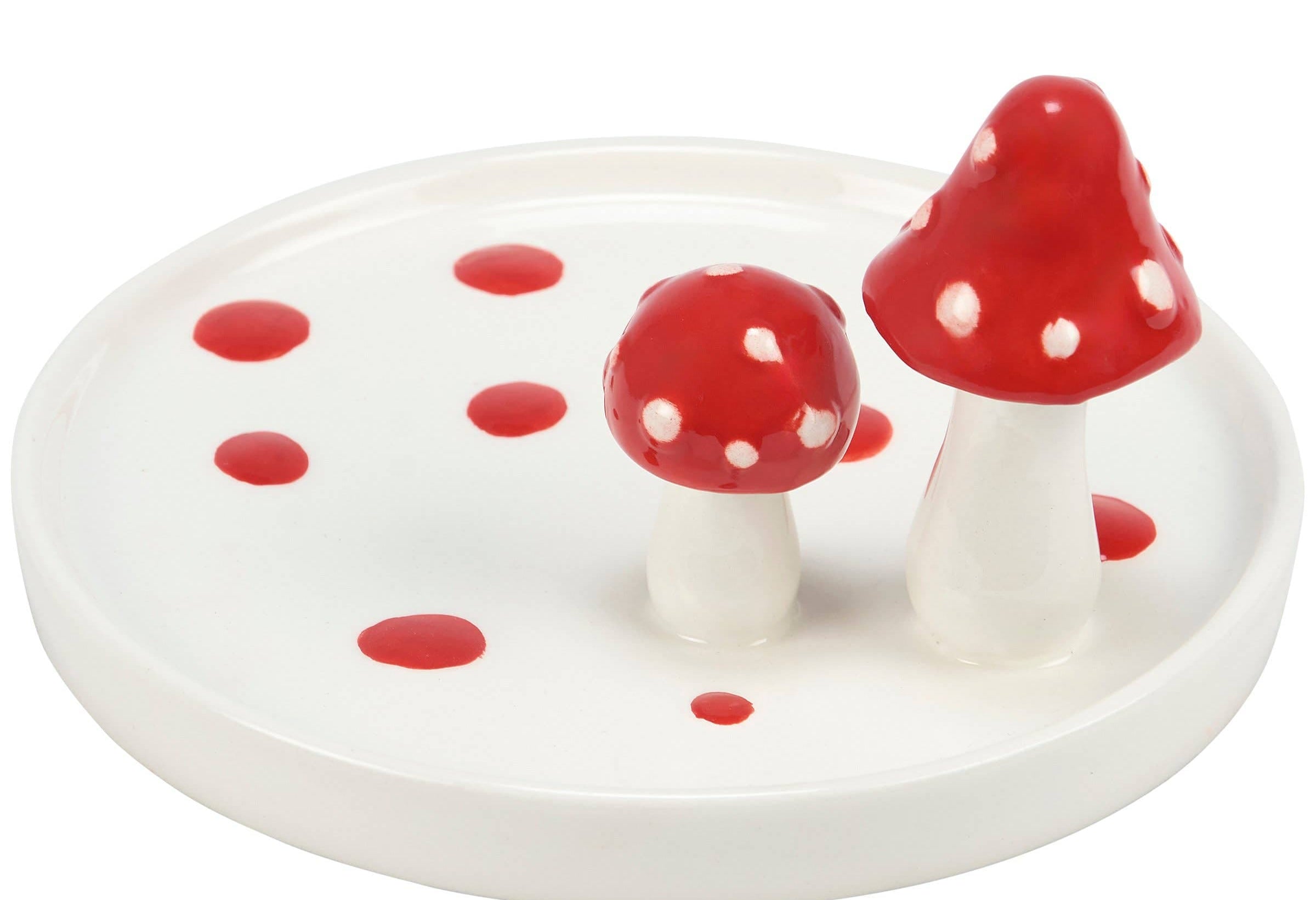 Ceramic jewelry tray shaped like a white plate with two red and white polka-dotted mushrooms. It has scattered red dots, giving a whimsical feel.