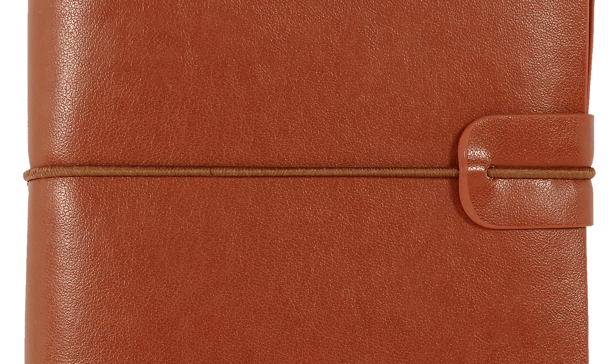 A brown leather journal with a textured cover is closed with a slim elastic band. A strap closure adds to its rustic and elegant appearance.