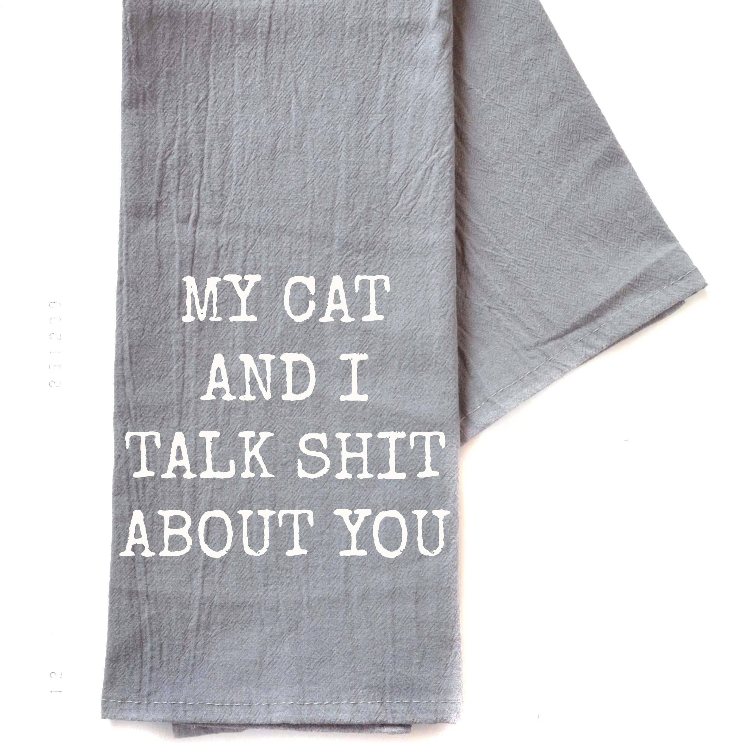 Gray dish towel with humorous black text saying, "My Cat and I talk shit about you" The tone is playful and sarcastic.