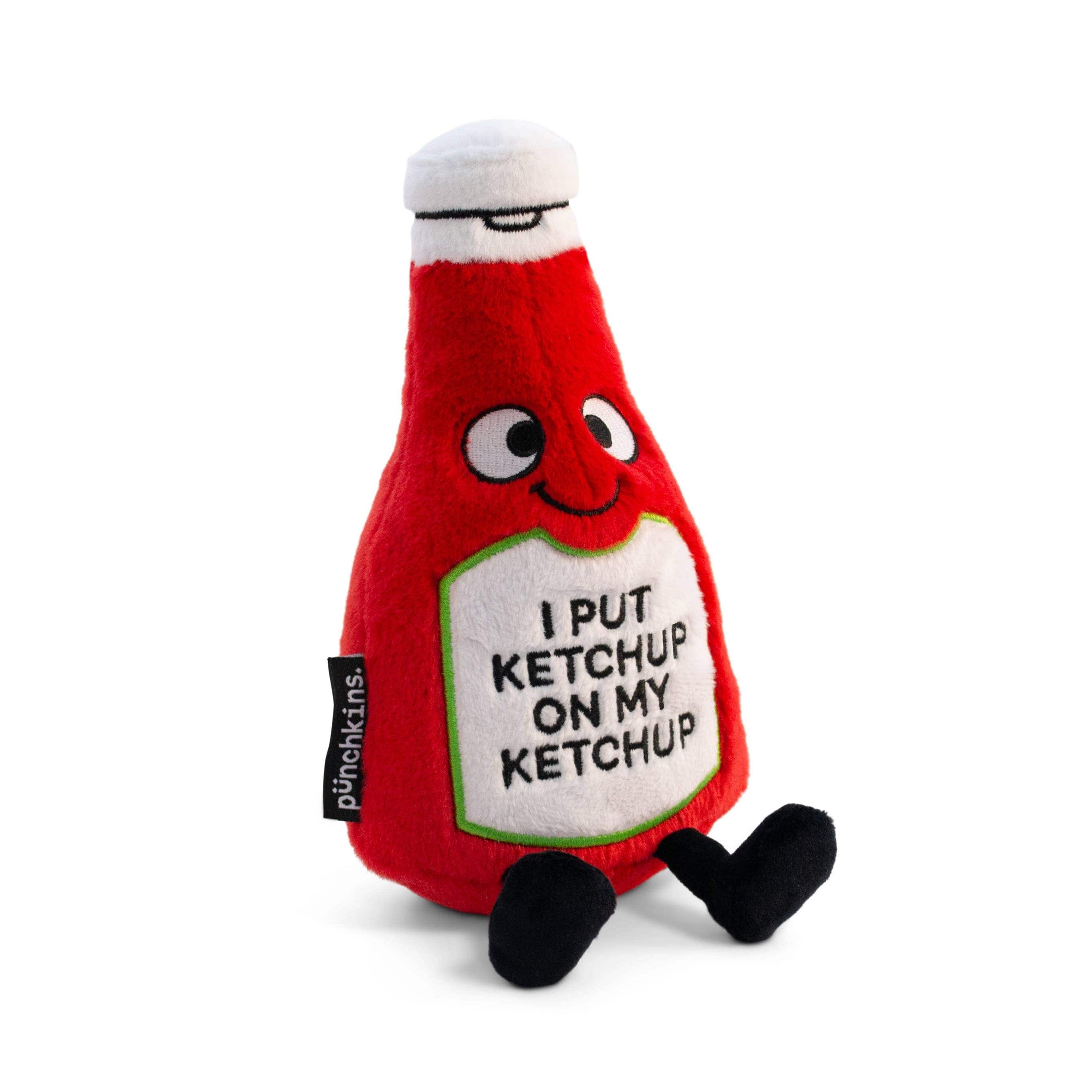 A ketchup bottle plushie with a smiley face and a white belly featuring black text that says "I put ketchup on my ketchup." It has a white lid and black legs sticking out.