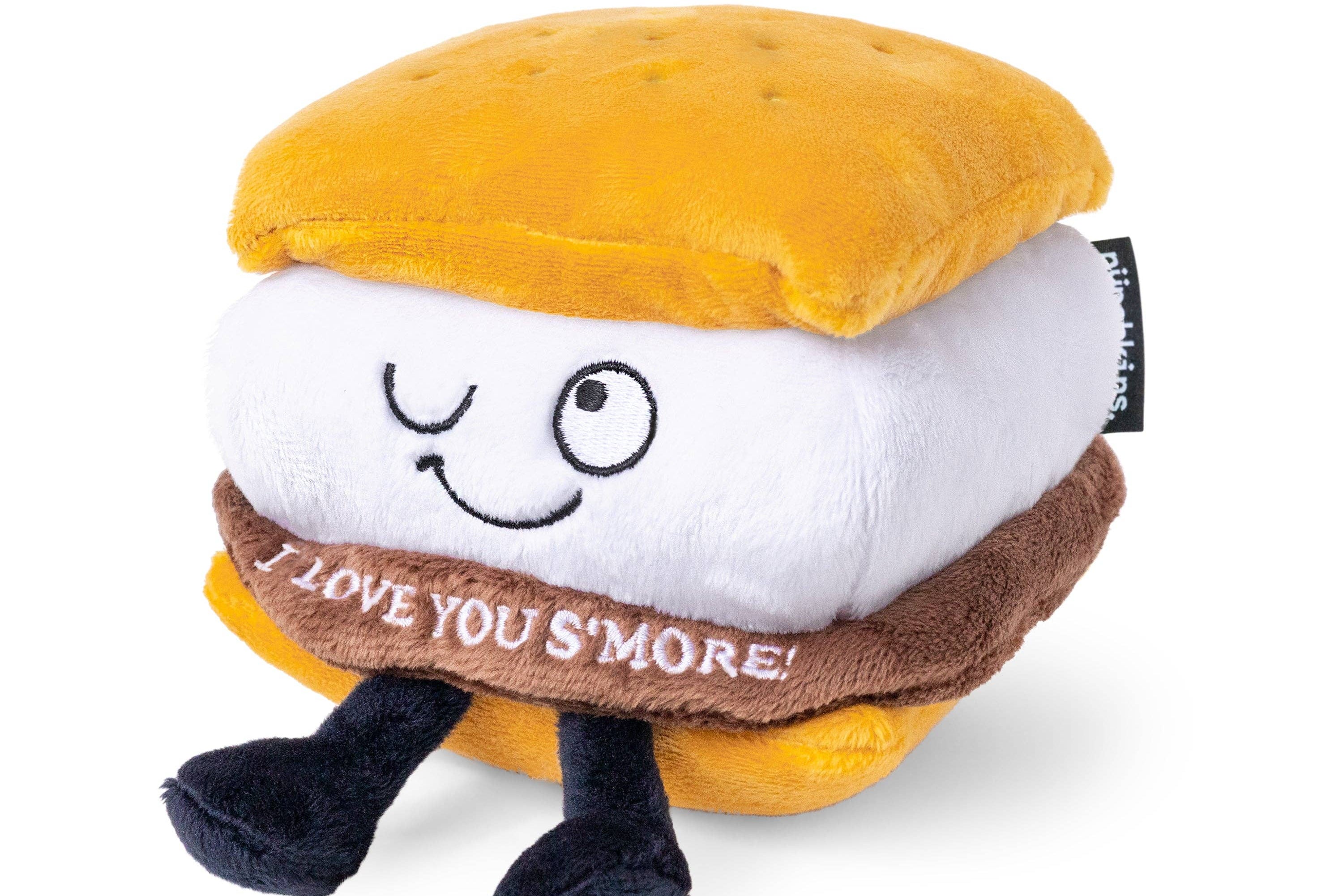 A plushie shaped like a s'more with a winky face. The chocolate layer features white lettering that reads "I love you s'more!"