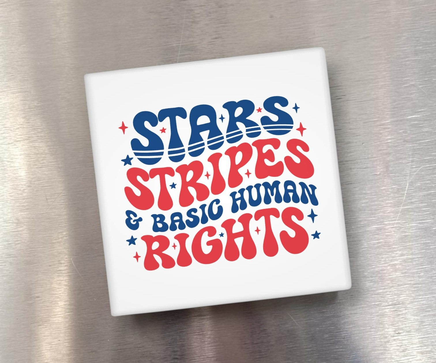 White square object with 'Stars Stripes & Basic Human Rights' text on a metallic surface
