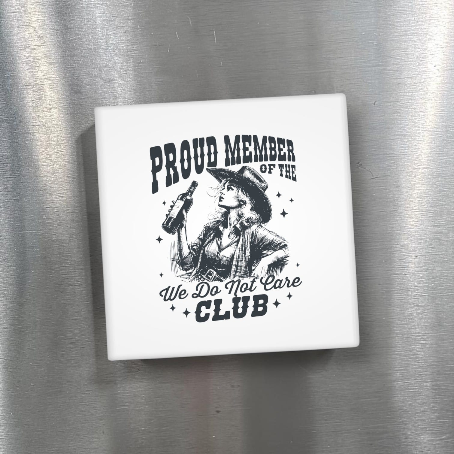 Fridge magnet with a design of a person in a cowboy hat and boots, holding a bottle, with text 'Proud Member of the We Do Not Care Club' on a metallic surface.