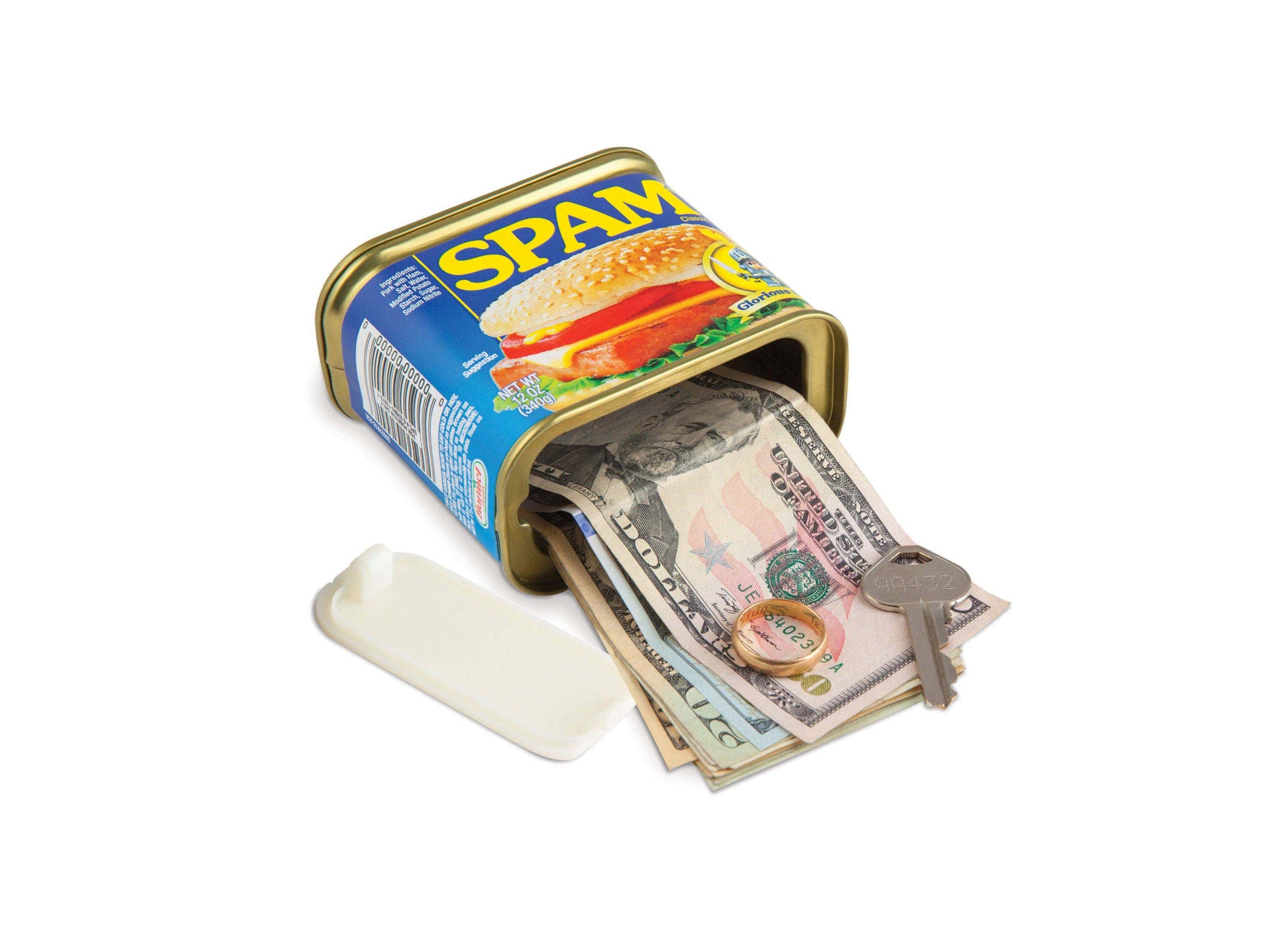 A Spam can with its lid open, revealing stacked US currency and a key inside. The setup suggests clever concealment, adding a humorous, unexpected twist.