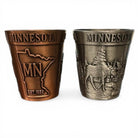 Two Minnesota-themed shot glasses, one bronze and one silver, on a white background.