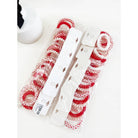 Pack of red and white spiral hair ties in plastic packaging, arranged neatly. A white object with a black bow is partially visible on the side. Bright and organized.