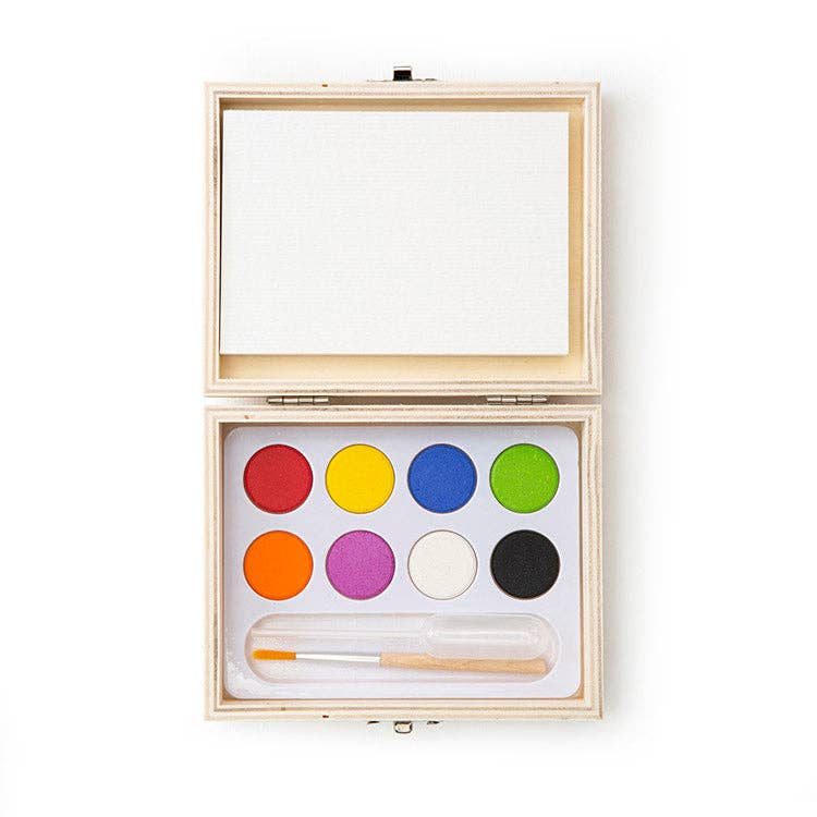 Wooden box with watercolor paints; includes eight vibrant colors: red, yellow, blue, green, orange, pink, white, black, and a paintbrush in a slot.