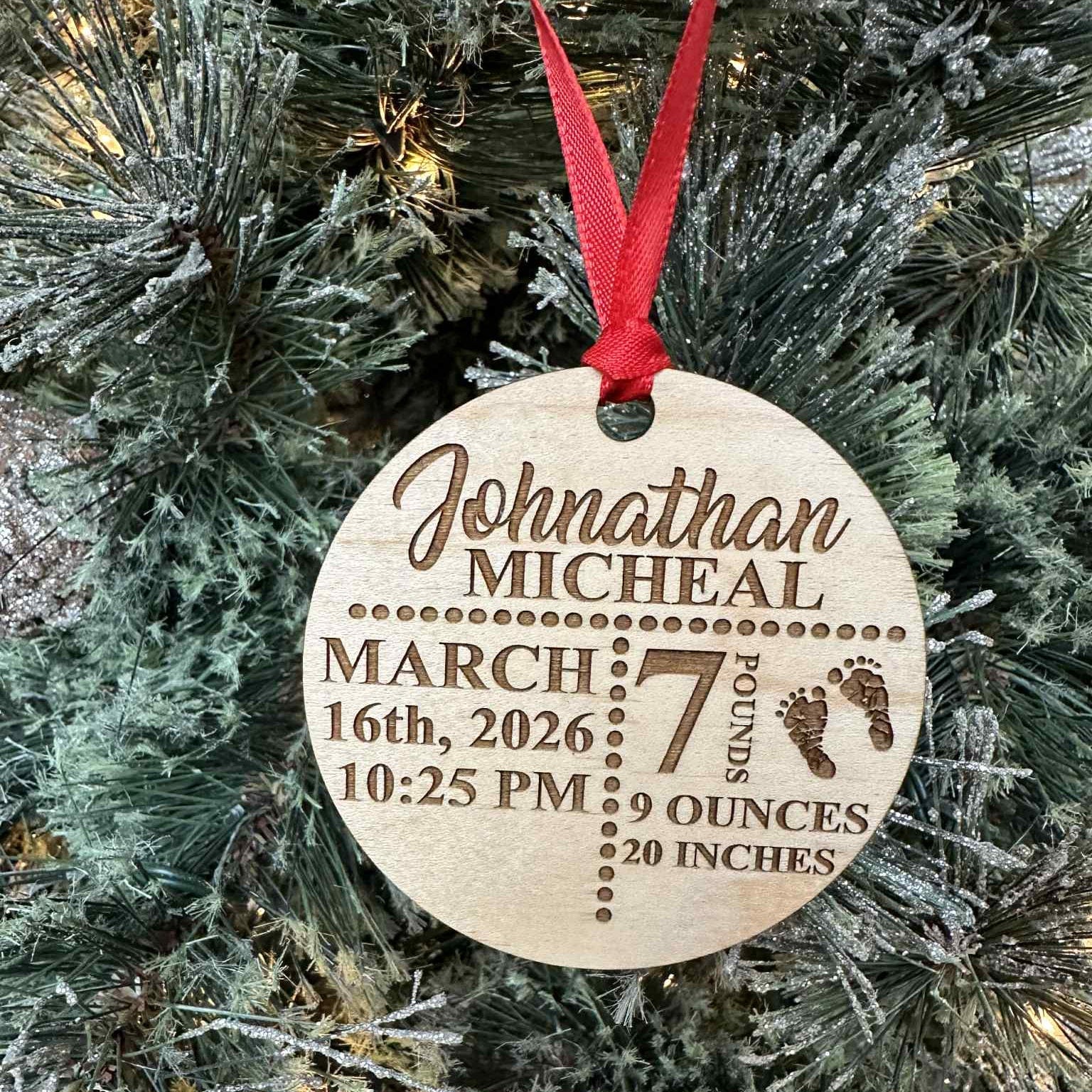 Wooden ornament with engraved baby details on a Christmas tree.
