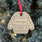 Decorative ornament shaped like a sweater with 'Georgia' on it, hanging on a Christmas tree.