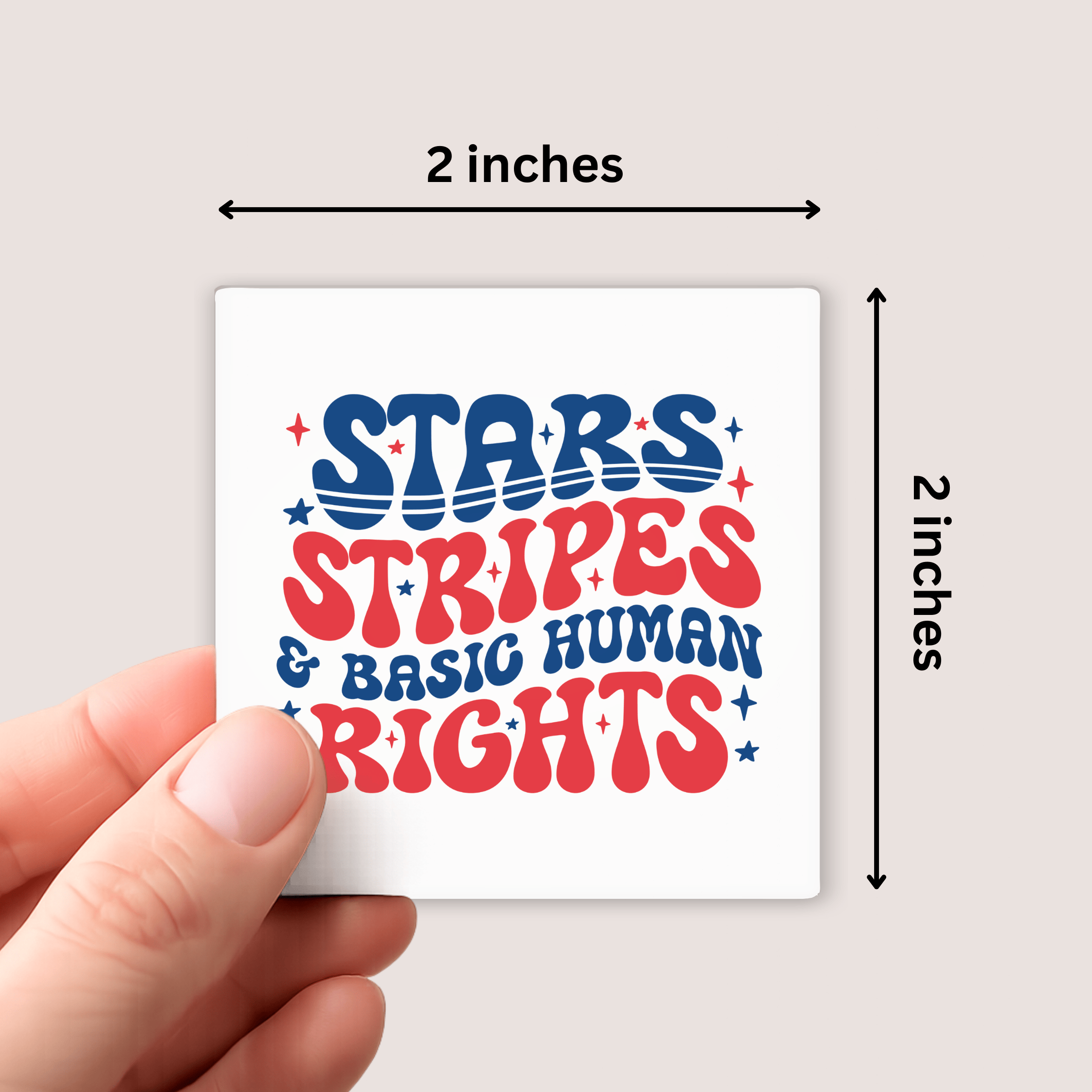 Hand holding a small square magnet with 'Stars Stripes & Basic Human Rights' text, measured at 2x2 inches.