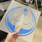 Hand holding a DTF print of the rebel loon design with blue and white colors in an indoor setting.