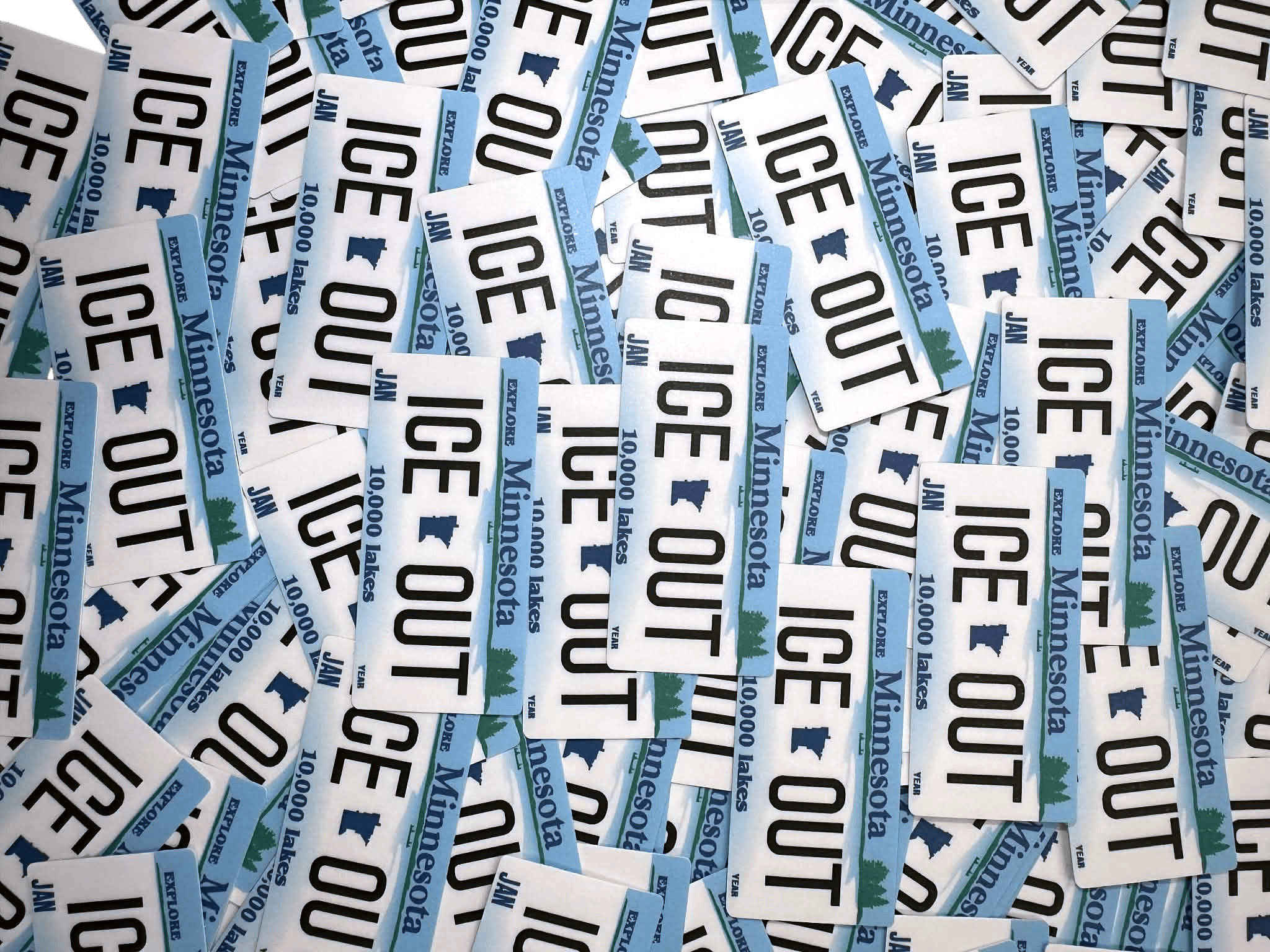 Collection of 'ICE OUT'Minnesota stickers scattered on a white background