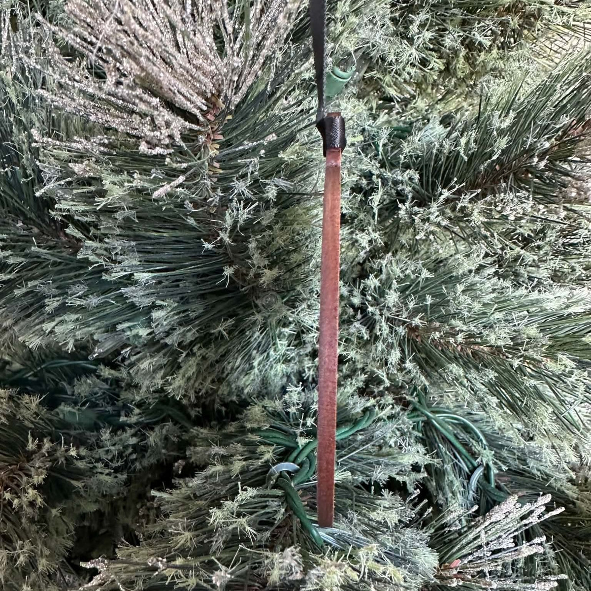 Rebel Loon engraved wood ornament hanging by a black ribbon on a Christmas tree