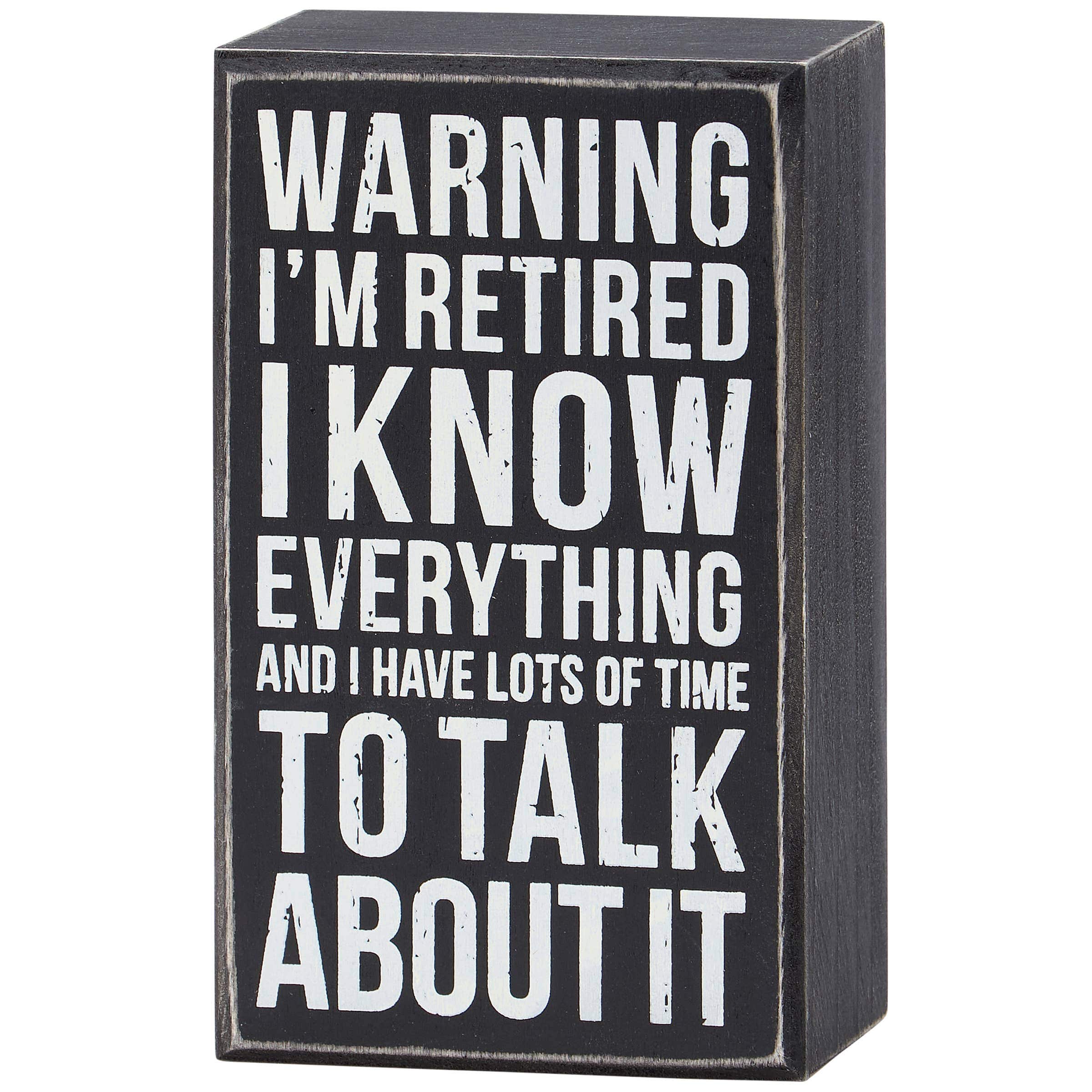 A square black wooden box sign with a distressed finish and white text that reads: 'WARNING I’M RETIRED I KNOW EVERYTHING AND I HAVE LOTS OF TIME TO TALK ABOUT IT.