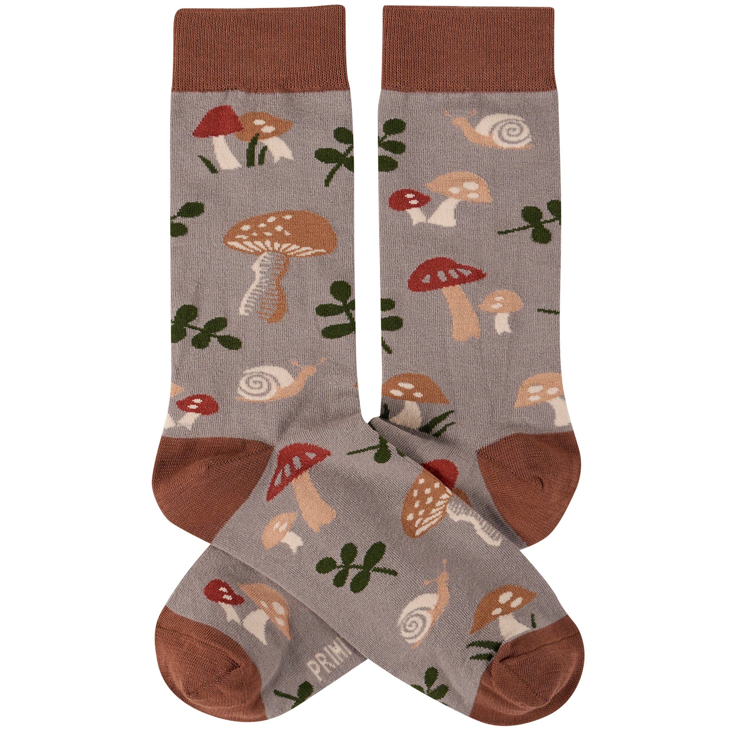 Brown and gray socks featuring playful prints of mushrooms, snails, and foliage. The design conveys a whimsical, nature-inspired theme.