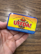 Mint tin with colorful label featuring cartoon character and text “U Betcha!” on a white background