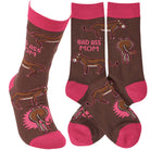 A pair of brown and pink socks from the featuring hand-illustrated donkey designs and the phrase "Bad Ass Mom" in pink.