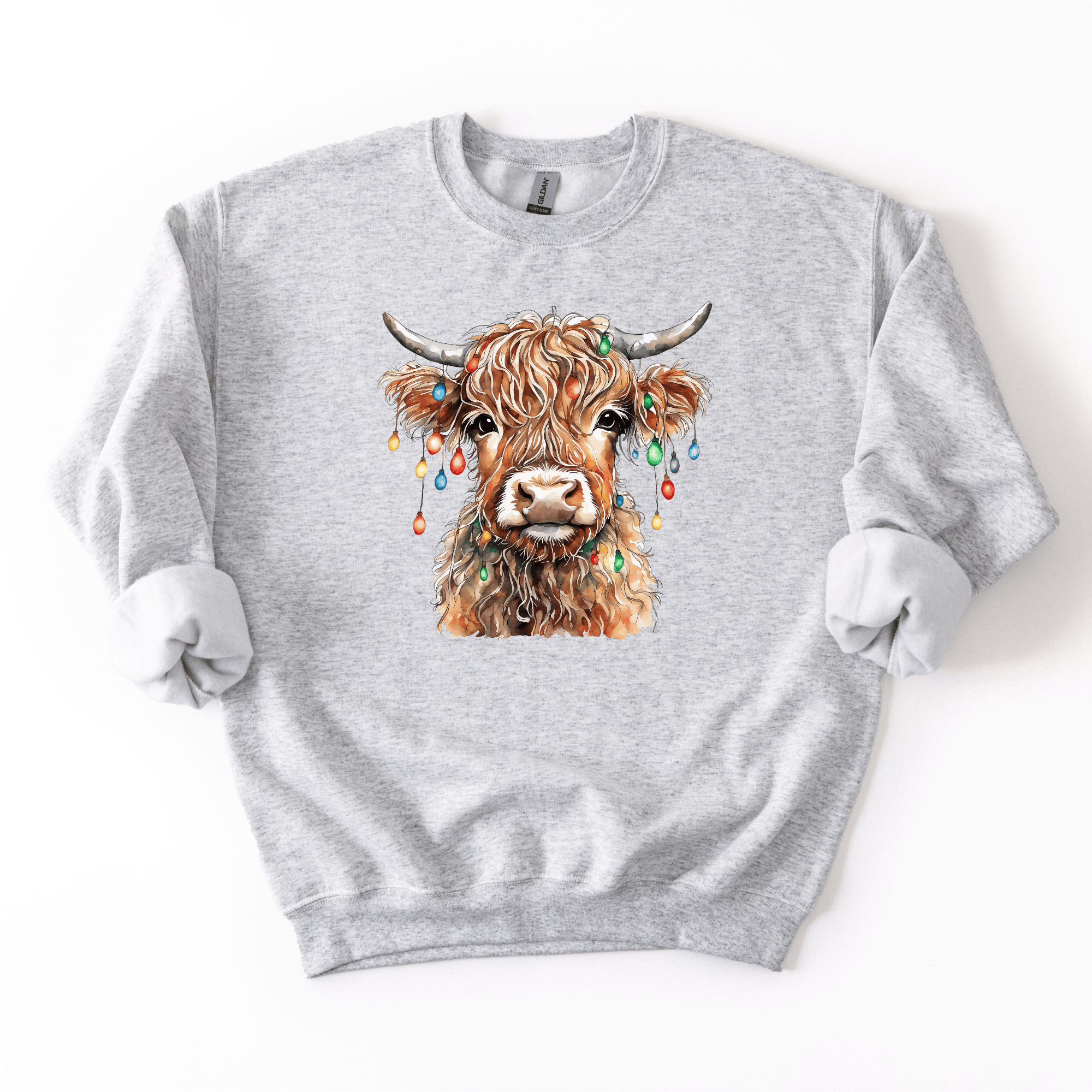 Gray sweatshirt with a colorful highland cow illustration wearing Christmas lights on a white background