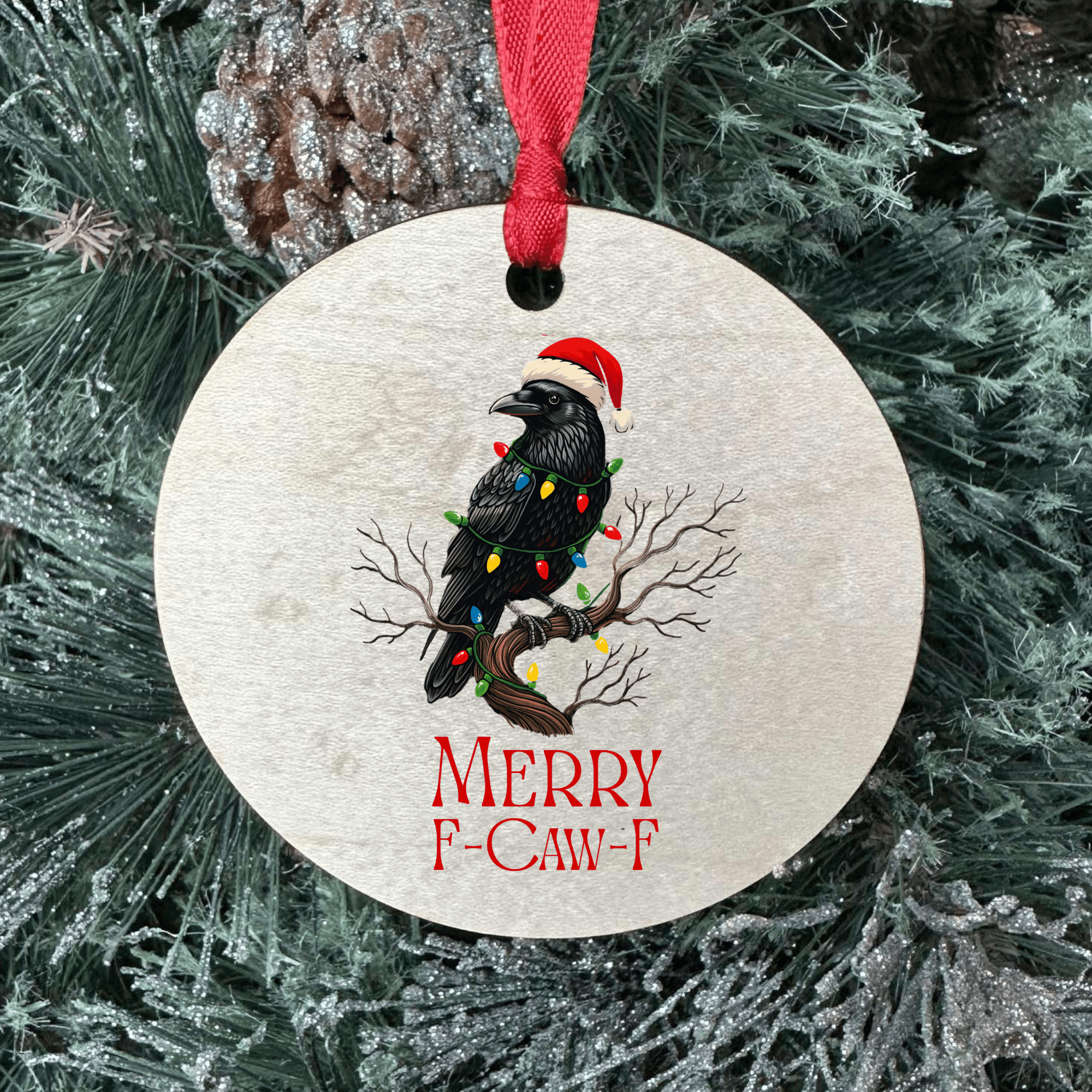 Christmas ornament with a black bird wearing a Santa hat and 'Merry F-Caw-F' text, hanging on a tree.