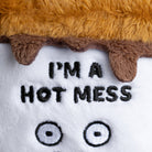 Close-up of black embroidery text that reads 'I'm a hot mess' on plushie, with neat stitching and clear lettering.