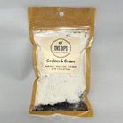 A brown, transparent package labeled "Cookies & Cream" from SNS Dips. It contains a white powder with dark specks, indicating a sweet mix.