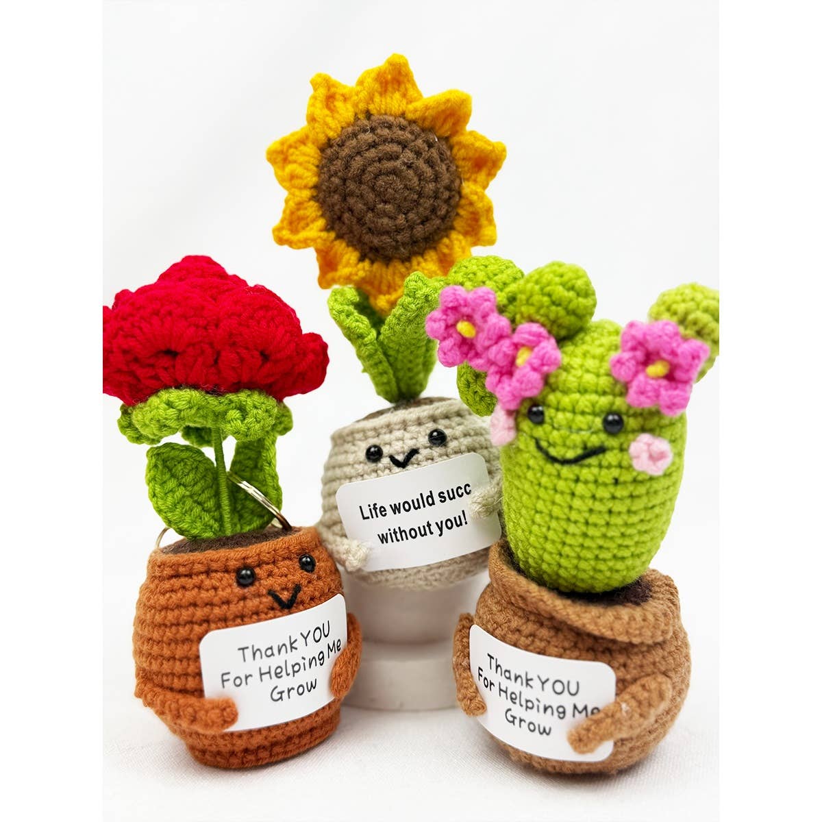 Set of crocheted plant toys with smiling faces and messages on a white background. They each read "Life would succ without you" and "Thank you for Helping me grow"