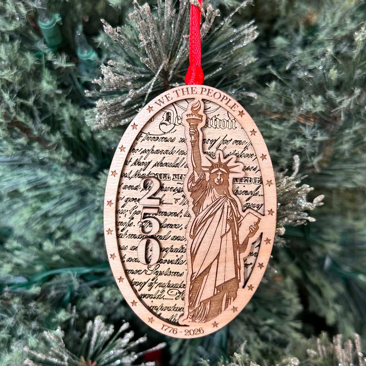 Statue of Liberty and the number 250 layered on top of another wood layer. We the people. 1776-2026