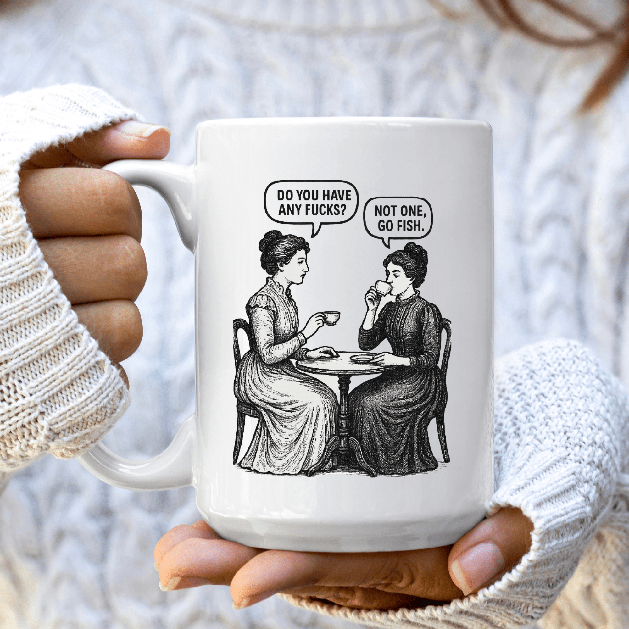 Person holding a mug with a graphic design of two women at a table and text bubbles.