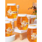 Honey jars with cartoon angel labels on a decorative stand against an orange background.